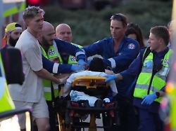 14 12 2025 australien sydney rettungskraefte transportieren eine person auf einer bahre nach einem zwischenfall am bondi beach in sydney
