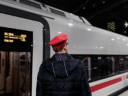 14 12 2025 berlin ein schaffner steht auf dem bahnsteig vor dem neuen ice l der deutschen bahn der als ice 1548 von berlin nach koeln faehrt