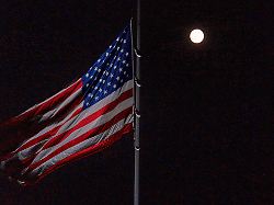 a full moon rises behind the half staff american flag on the south lawn of the white house wednesday nov 5 2025 in washington