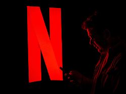 ankara turkiye november 1 logo of netflix is displayed on a digital screen with a man looking at his mobile phone in ankara turkiye on november 1 2025
