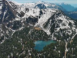 aerial view of mountain lake with snow mountains and green forest hridsko lake in montenegro