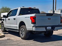 april 14 2024 emporia kansas u s a recently purchased ford f150 all electric lightning pickup truck is plugged into a tesla supercharger station in the parking lot of the emporia west shopping plaza