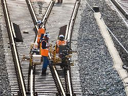 cntv bahnsanierung arbeiter der db bahn arbeiten mit orangenen schutzwesten und schutzhelmen an neuen gleisen verlegen schienen und betonschwellen