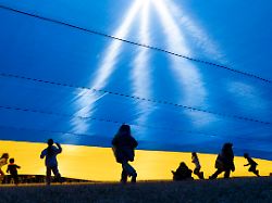 children play under an ukrainian flag as demonstrators rally in support of ukraine at the ellipse near the white house in washington saturday march 8 2025