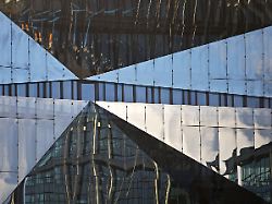 cube berlin wuerfelfoermiges buerogebaeude mit gefalteter glasfassade in der sich die umgebung spiegelt detail washingtonplatz berlin deutschland