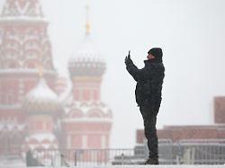 dieses foto wird von der russischen staatsagentur tass zur verfuegung gestellt russia moscow december 10 2023 a man takes pictures in red square with st basil s cathedral in the background
