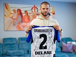 der ehemalige fussballspieler dennis diekmeier haelt in seiner wohnung ein trikot des hamburger sv mit dem namen seiner aeltesten tochter delani in den haenden