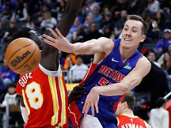detroit pistons forward duncan robinson right passes the ball past atlanta hawks forward mouhamed gueye left during the second half of an nba basketball game friday dec 12 2025 in detroit