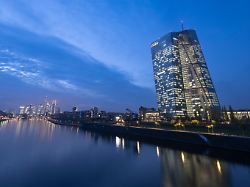 die lichter in den bueros der europaeischen zentralbank leuchten im letzten tageslicht waehrend sich die skyline im main spiegelt