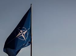 die nato flagge und die deutschlandflagge am bundeskanzleramt im hintergrund das reichstagsgebaeude in berlin 11 12 2025