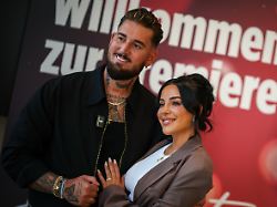 die reality tv promis mike heiter l und seine ehefrau leyla heiter ehemals leyla lahouar stehen bei einem fototermin vor einer werbewand fuer die doku zu ihrer hochzeit