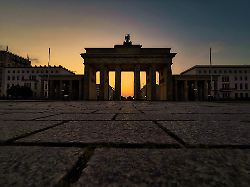 die sonne geht hinter dem brandenburger tor auf