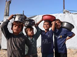 displaced palestinian children carry the food containers they receive from a charity kitchen in a displacement camp inside gaza port on november 19 2025