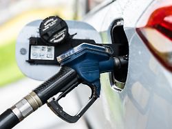 ein auto wird an einer zapfsaeule mithilfe eines tankruessels an einer tankstelle betankt