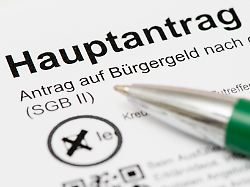 ein kugelschreiber liegt auf dem formular hauptantrag auf buergergeld