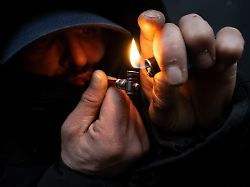 ein mann zuendet sich im bahnhofsviertel von frankfurt eine crackpfeife an