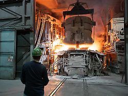 ein mitarbeiter steht in einer werkhalle der bgh edelstahl freital gmbh hinter einem schrottkorb an einem lichtbogenofen anlass ist der 4 saechsische stahlgipfel