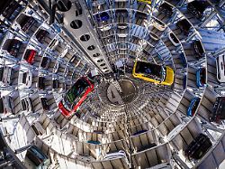 ein volkswagen id 7 gtx tourer l und ein volkswagen t roc r werden bei einem fototermin in einem der beiden autotuerme der volkswagen autostadt aus boxen gehoben