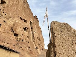 eine taliban flagge weht nahe der ueberreste der von den taliban gesprengten buddha statuen von bamian