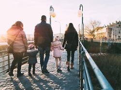father walking down the street with his two families on a sunny winter s afternoon