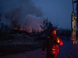 feuerwehrleute stehen in der naehe der einschlagstelle einer russischen artilleriegranate waehrend schwarzer rauch in die luft in kramatorsk aufsteigt