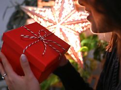 illustration 06 12 2025 berlin eine frau haelt eine mit einer schleife verzierte geschenkbox