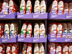 milka weihnachtsmann aus weisser und brauner schokolade in einem supermarktregal wintersuessigkeiten mit nuessen trier deutschland