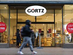 passanten gehen an einer filiale des schuhhaendlers goertz in der innenstadt vorbei