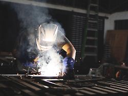 professioneller schweisser der an der werkbank arbeitet