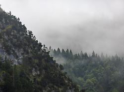 regenwolken und dichter nebel verhuellen die haenge des kofel die markante felsformation in den ammergauer alpen zeigt sich an diesem tag in mystischer und duesterer stimmung