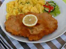 schnitzel wienerart mit knuspriger panade und kartoffelsalat serviert in einem gasthof in der fraenkischen schweiz