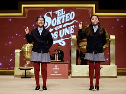 schoolgirls show the winning prize of spain s christmas lottery el gordo the fat one at the royal theatre in madrid on december 22 2025