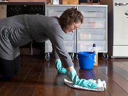 thema putzen schwangere frau kniet auf dem boden und putzt mit einem lappen