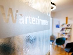 wartezimmer ist auf der tuer eines wartezimmers in einer arztpraxis zu lesen