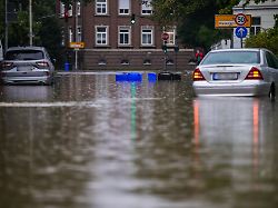 zwei autos stehen in den wassermassen in einer ueberschwemmten strasse in moenchengladbach rheydt
