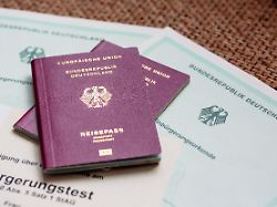 zwei deutsche reisepaesse liegen auf einbuergerungsurkunden der bundesrepublik deutschland sowie einem einbuergerungstest