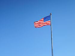 american flag waving on a flagpole against a clear blue sky smaf03187