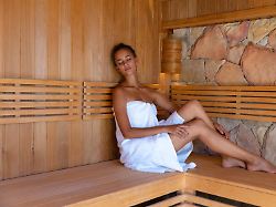 caucasian young woman in a bathrobe relaxing in the sauna 1