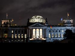 die fenster im reichstagsgebaeude des deutschen bundestags sind am fruehen morgen in berlin erleuchtet