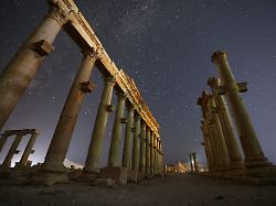 die ruinen der antiken stadt palmyra unter einem sternenuebersaeten himmel in den spaeten abendstunden