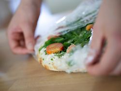 ein maedchen packt eine tiefgekuehlte pizza aus