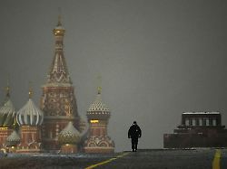 ein polizist geht ueber den roten platz der wegen der silvesterfeierlichkeiten geschlossen ist im hintergrund links ist die basilius kathedrale zu sehen
