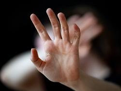 eine frau haelt ihre haende vor das gesicht