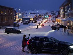 eine frau reinigt ihr auto vom schnee