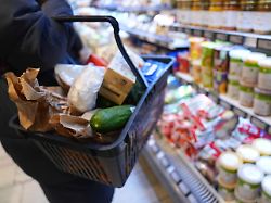 eine kundin geht mit einem einkaufskorb und ihrem einkauf an den regalen in einem supermarkt vorbei das statistische bundesamt gibt die inflationsrate fuer dezember und das gesamtjahr 2025 bekannt 1