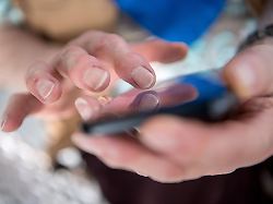 eine seniorin tippt auf ihrem smartphone