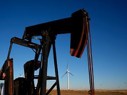 eine tiefpumpe arbeitet im vordergrund waehrend sich in der ferne die windturbinen des buckeye wind energy windparks erheben