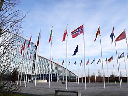 fahnen flattern im wind vor dem nato hauptquartier in bruessel