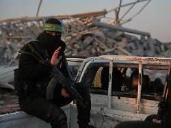 hamas kaempfer suchen nach den ueberresten einer israelischen geisel im zeitoun viertel von gaza stadt