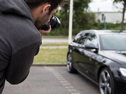 illustration ein mann steht am 06 07 2018 in hamburg auf einem parkplatz und fotografiert sein auto gestellte szene